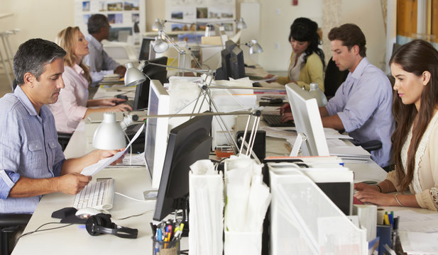 Team Working At Desks In Office