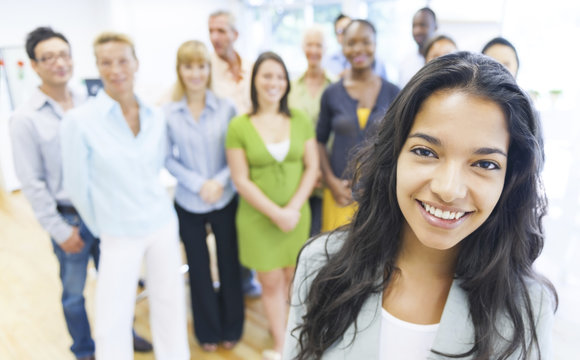 Beautiful young woman with colleagues in the background