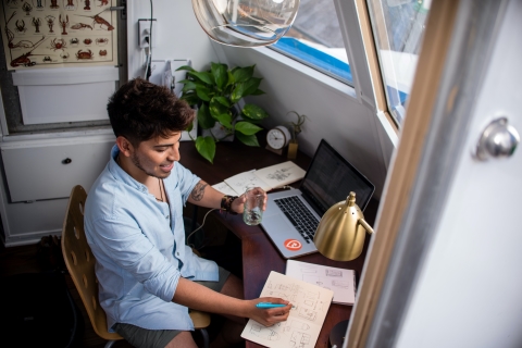 Young man writing notes in diary