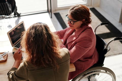 Two women talking over a laptop