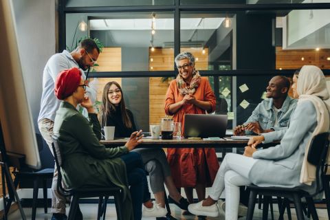 People sitting and standing around a conference table